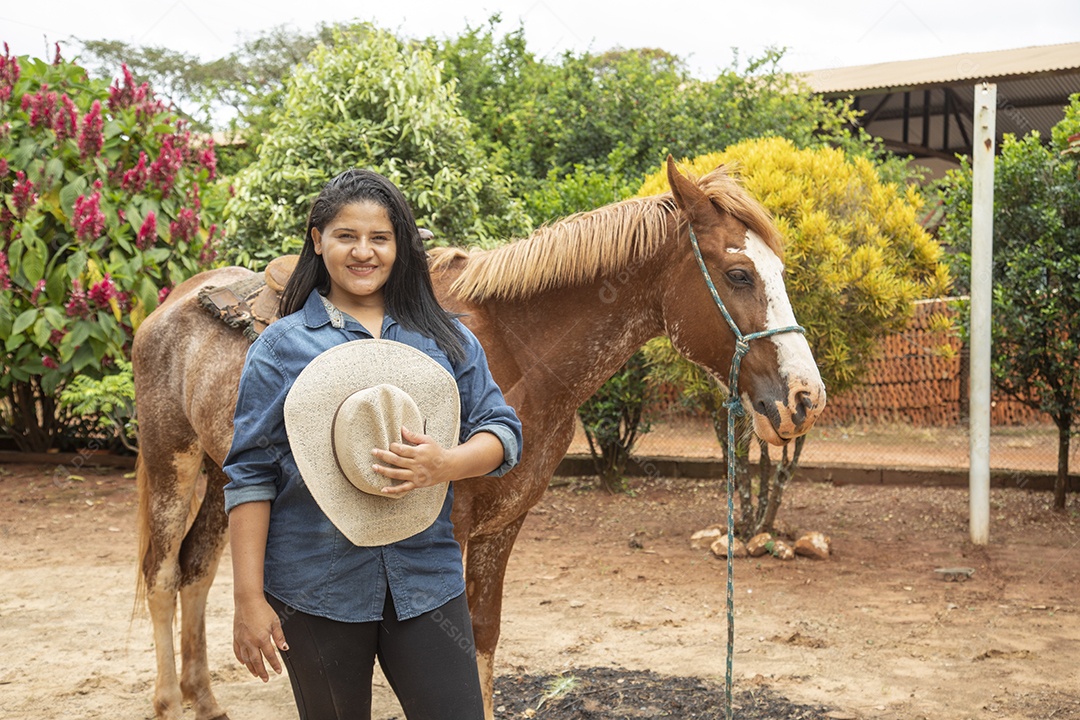 Mulher jovem agricultora sobre fazenda com seu cavalo