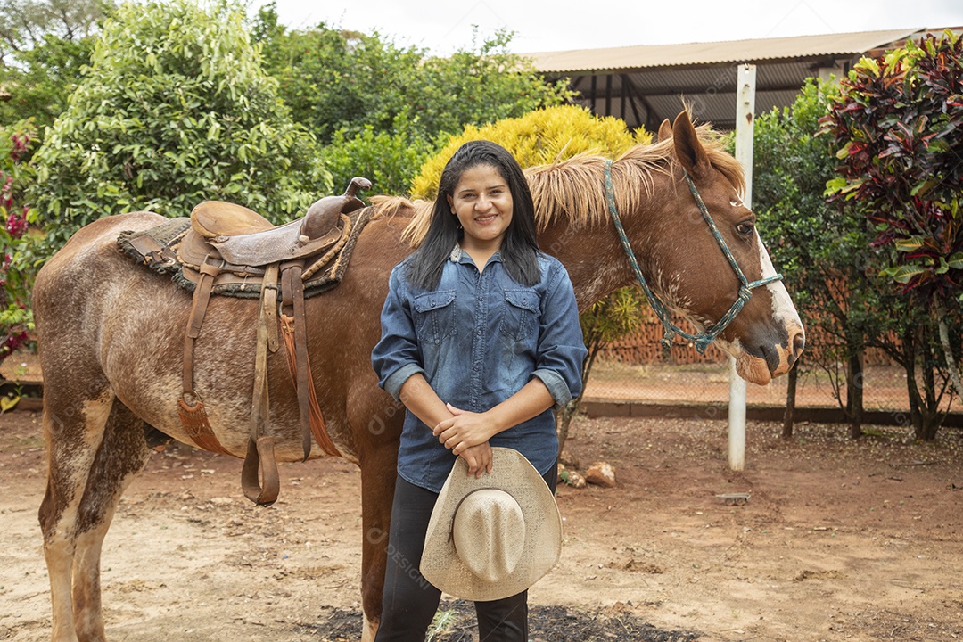 Mulher jovem agricultora sobre fazenda com seu cavalo