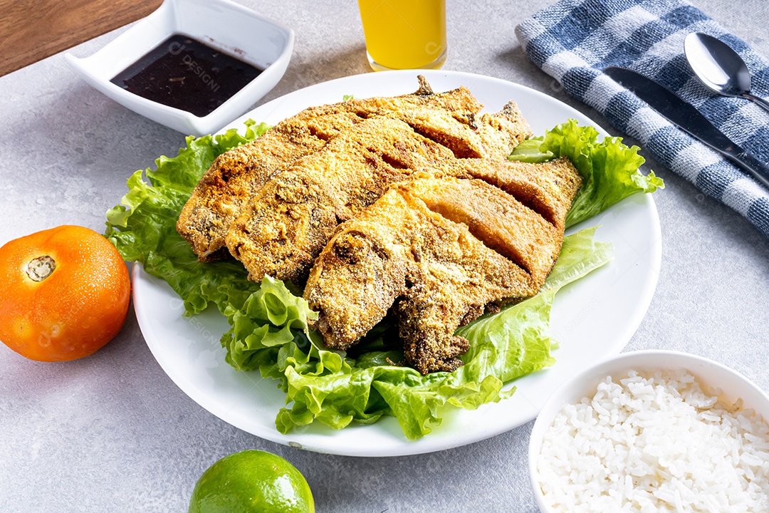 Peixe peroa limpo na tábua de madeira e coentros, pronto a fritar.