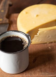 Queijo e café, cena típica do Brasil com diferentes queijos e café em uma mesa de madeira rústica