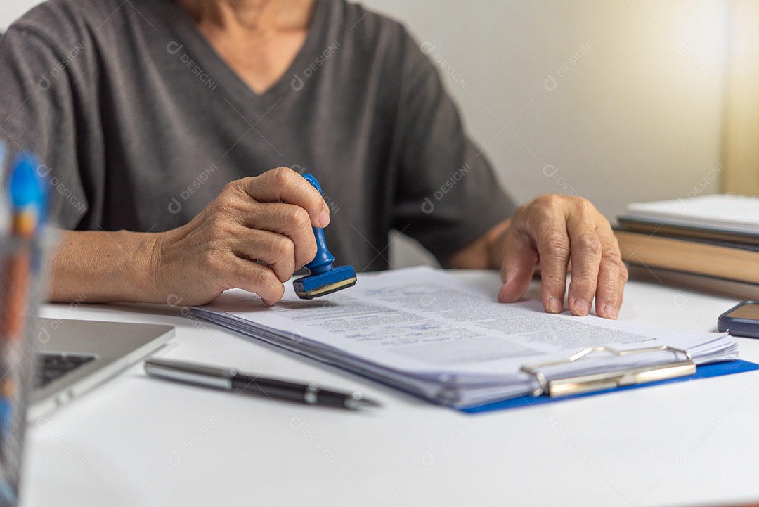 Mulher carimbando a aprovação de documentos bancários de finanças de trabalho ou de marketing de investimento