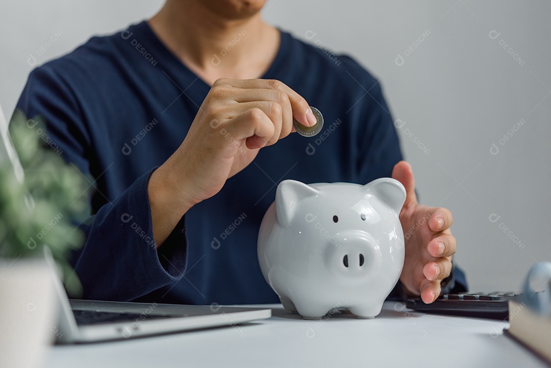 Homem economizando dinheiro em um cofrinho. Conceito de poupança de negócios e investimento financeiro de dinheiro.