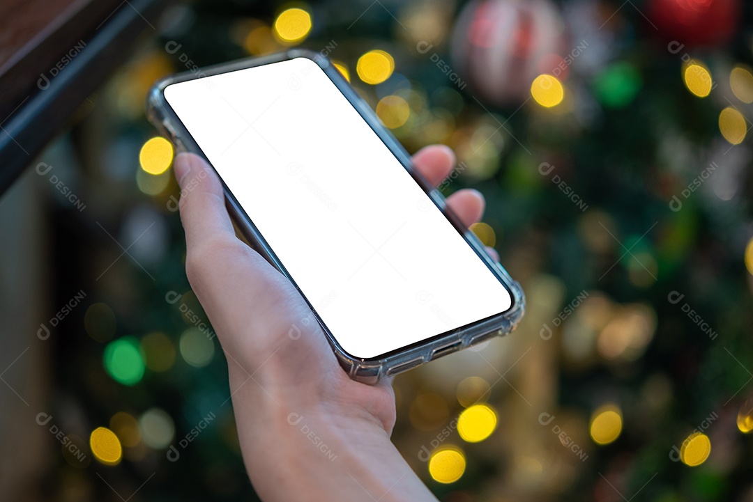 mão feminina segurando e usando uma simulação de telefone celular com fundo bokeh.