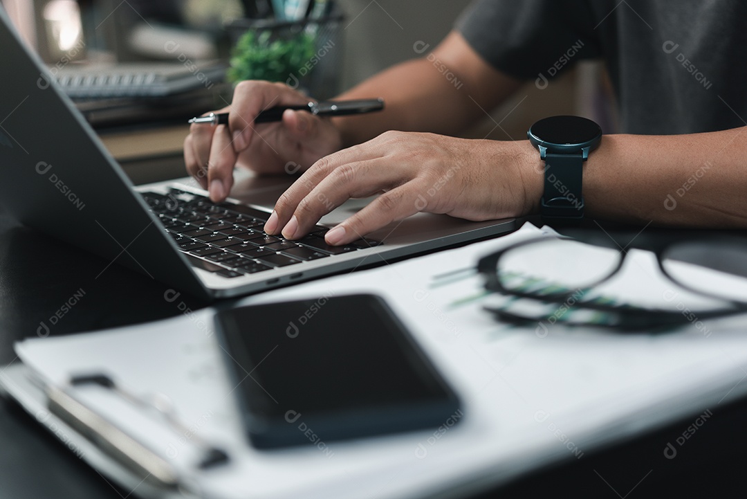 Homem usando laptop em sua estratégia de documento local de trabalho.