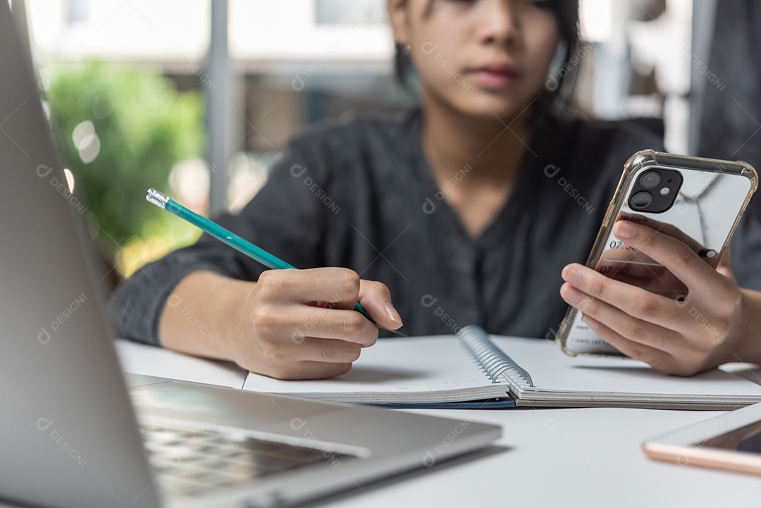 mulher trabalhando no computador portátil e usando o telefone celular no conceito de tecnologia digital de mesa.