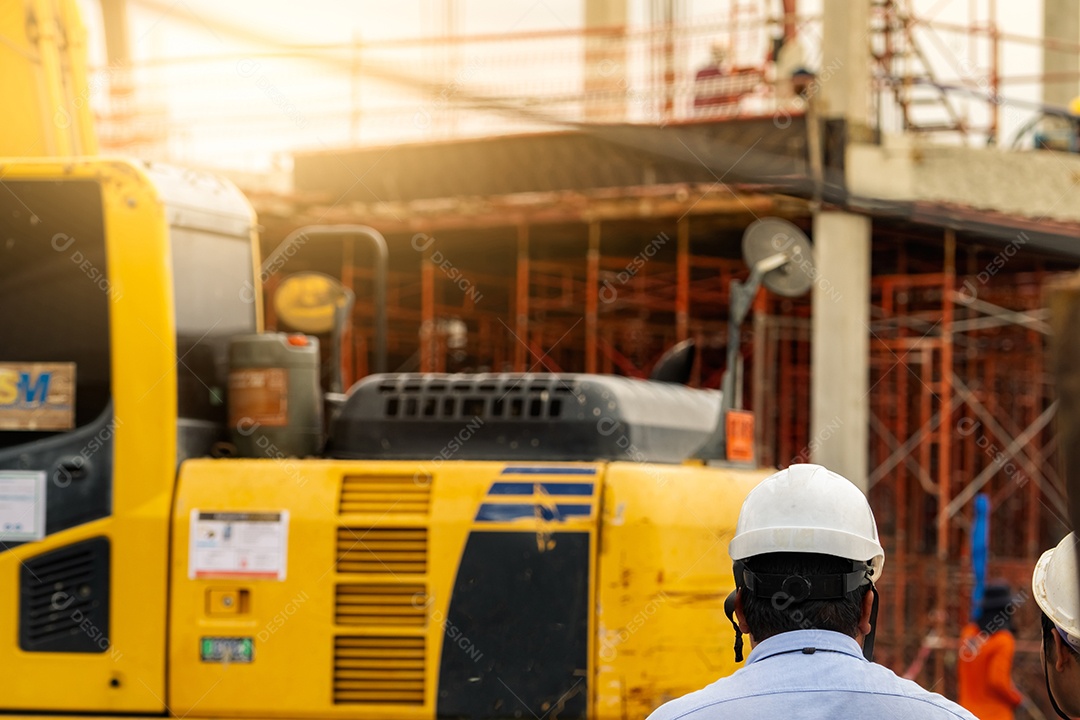 Engenheiro civil e equipe inspecionam canteiro de obras de empreendimento habitacional