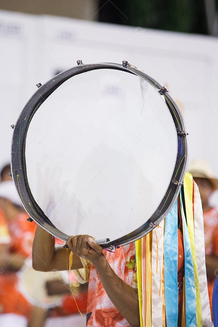 homem segurando um grande pandeiro durante ensaio de carnaval no Rio de Janeiro, Brasil.
