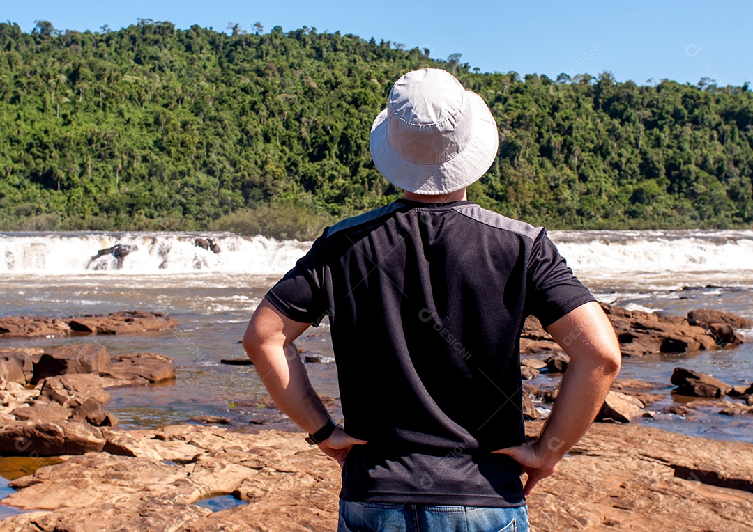 Homem de costas observando cachoeira (Salto do Yucuma-Brasil)