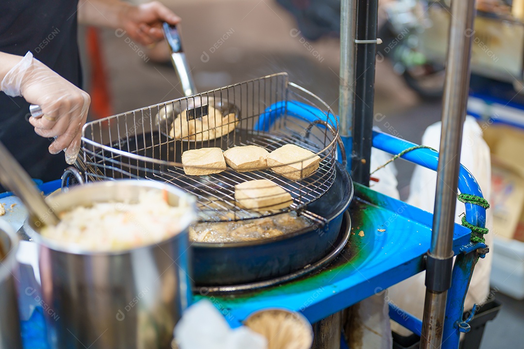 Cozinhando à mão o Stinky Tofu no mercado noturno, famosa rua taiwanesa