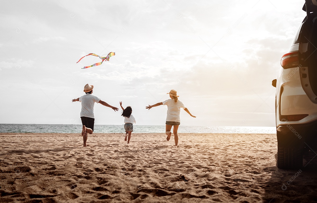 Linda família feliz passeando pela praia