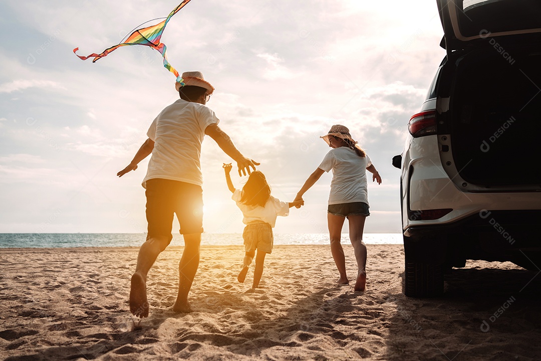 Linda família feliz passeando pela praia