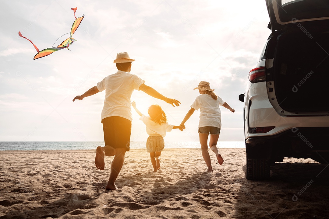 Linda família feliz passeando pela praia