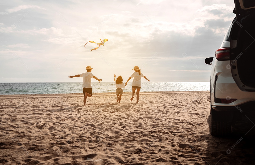 Linda família feliz passeando pela praia