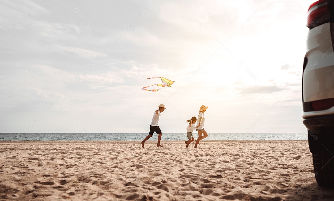 Linda família feliz passeando pela praia