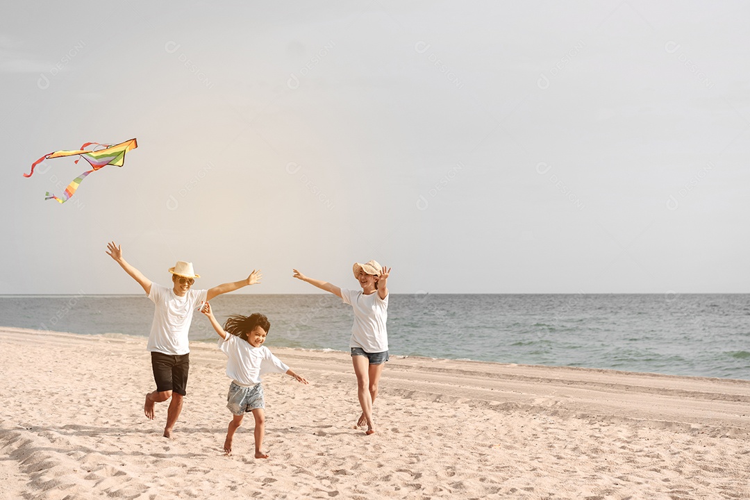 Linda família feliz passeando pela praia