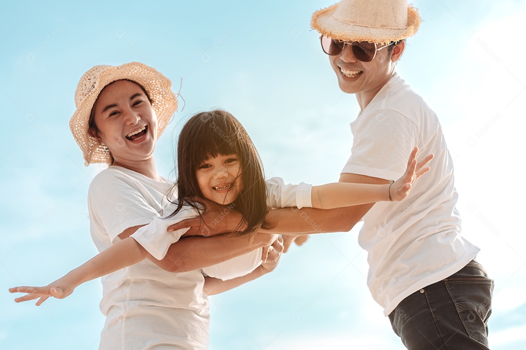 Linda família feliz brincando pela praia