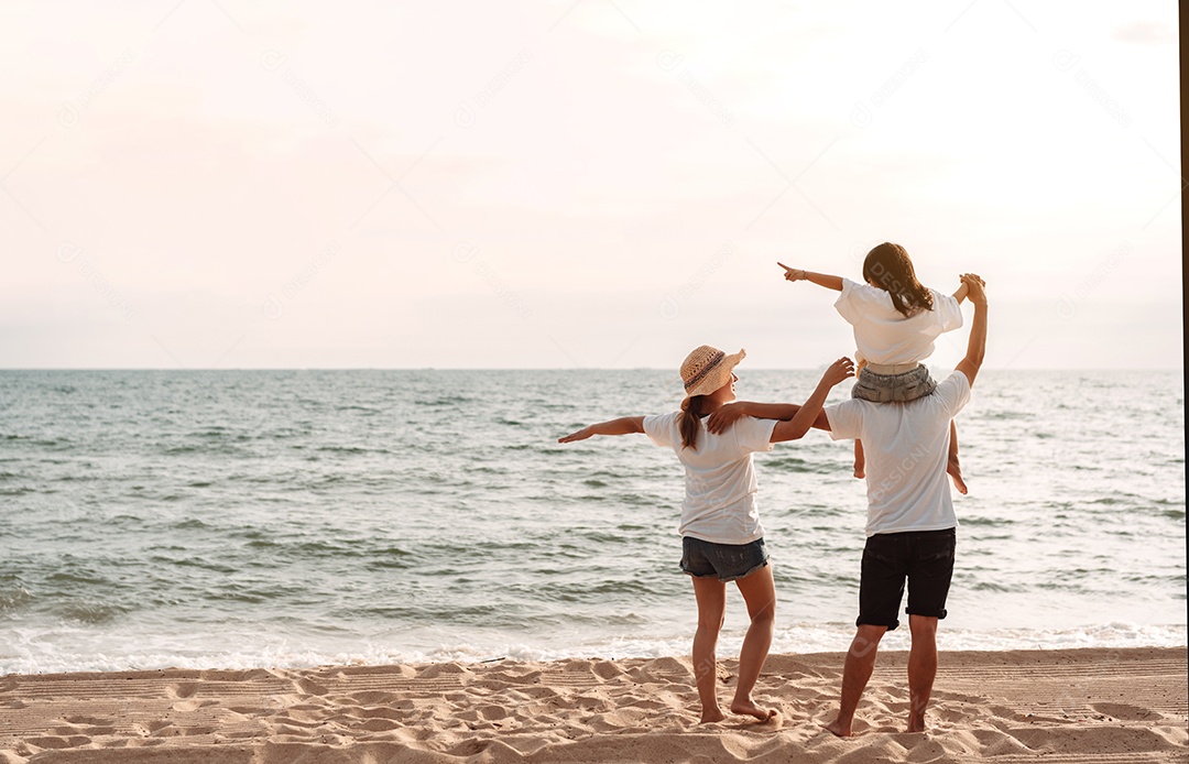 Linda família feliz brincando pela praia