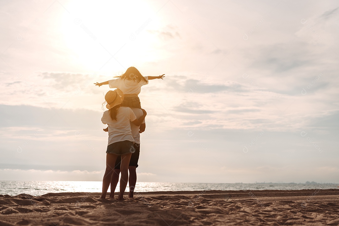 Linda família feliz brincando pela praia