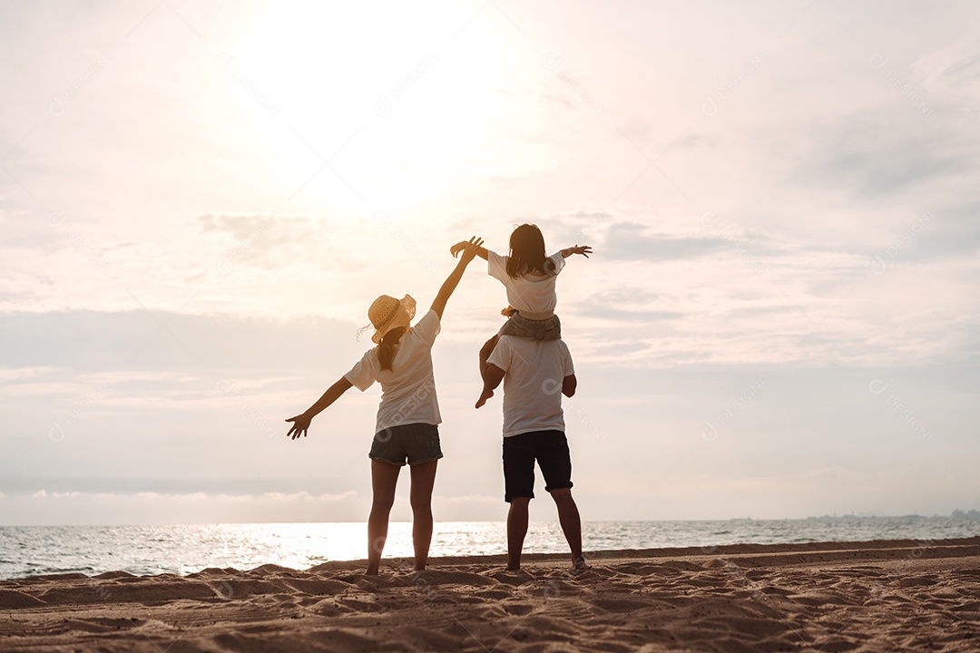 Linda família feliz brincando pela praia