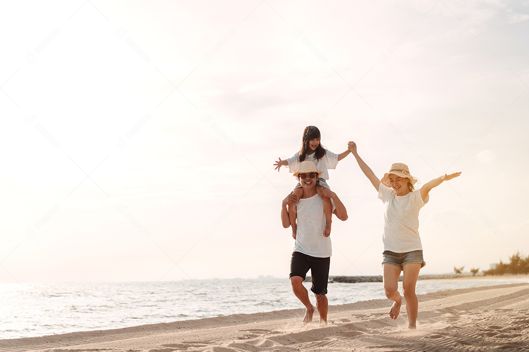 Linda família feliz passeando pela praia