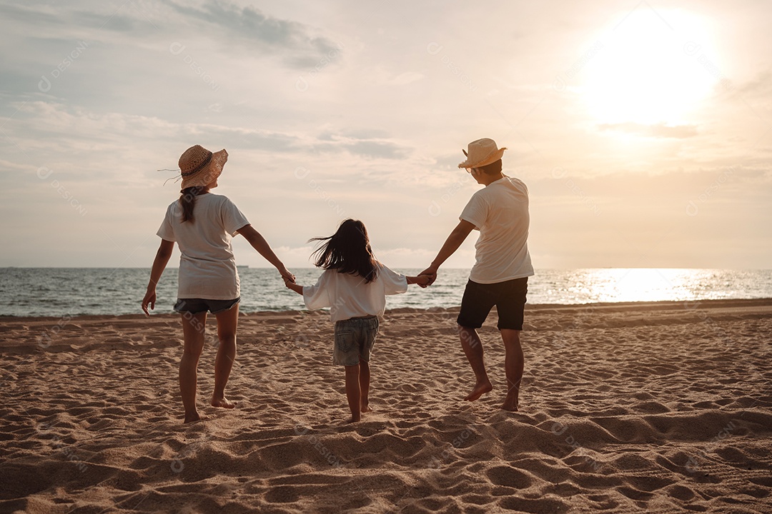 Linda família feliz passeando pela praia