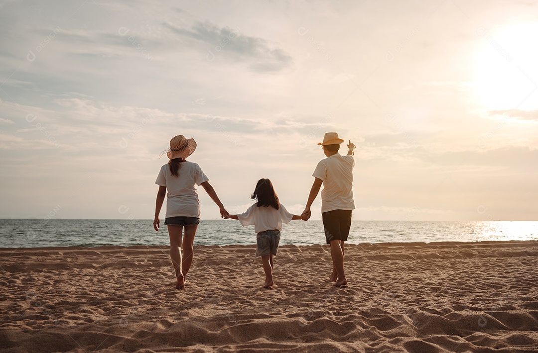 Linda família feliz passeando pela praia