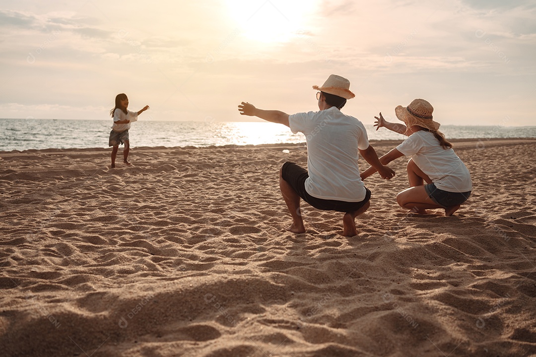 Linda família feliz passeando pela praia