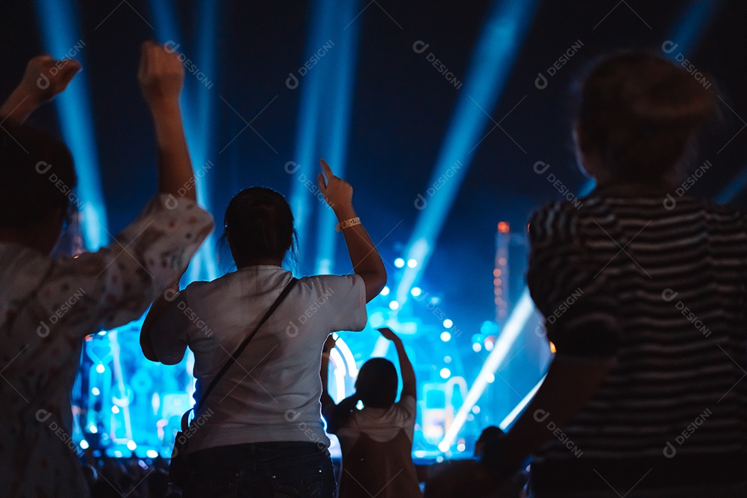 Multidão de mãos levantando as luzes do palco do concerto e a silhueta do público de fãs