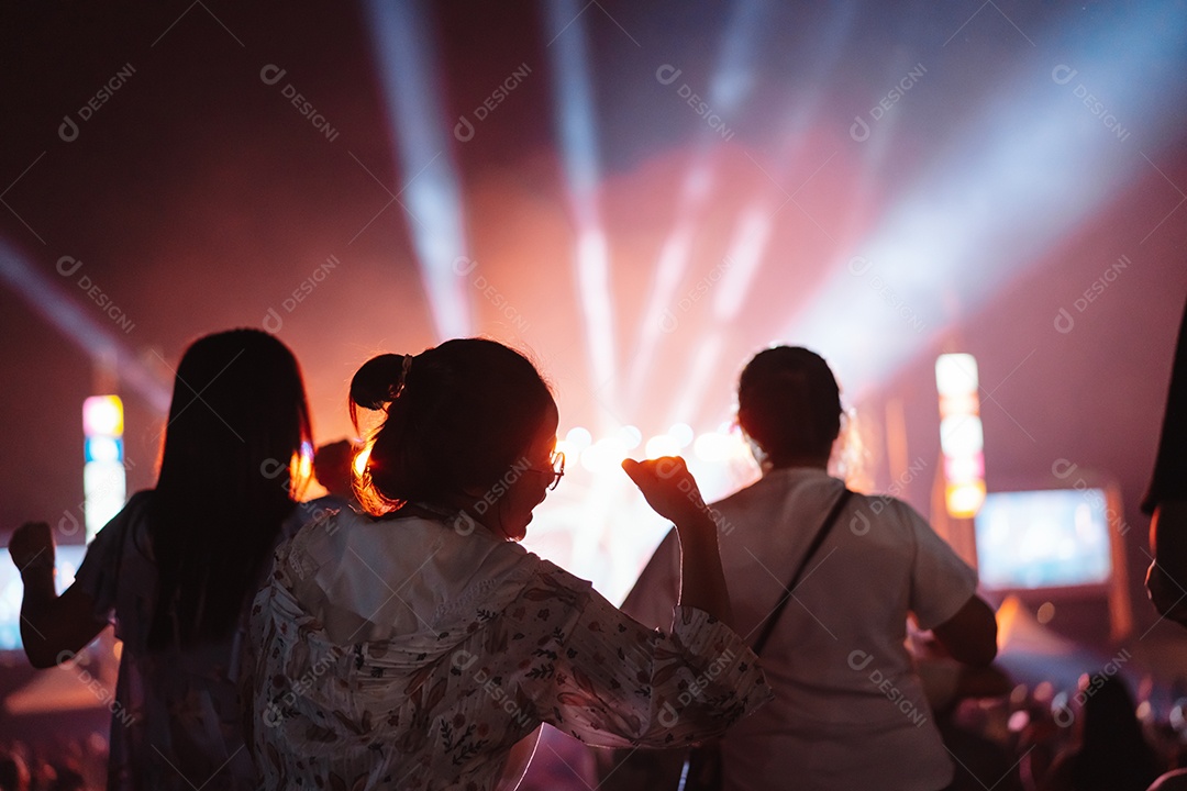 Multidão de mãos levantando as luzes do palco do concerto e a silhueta do público de fãs