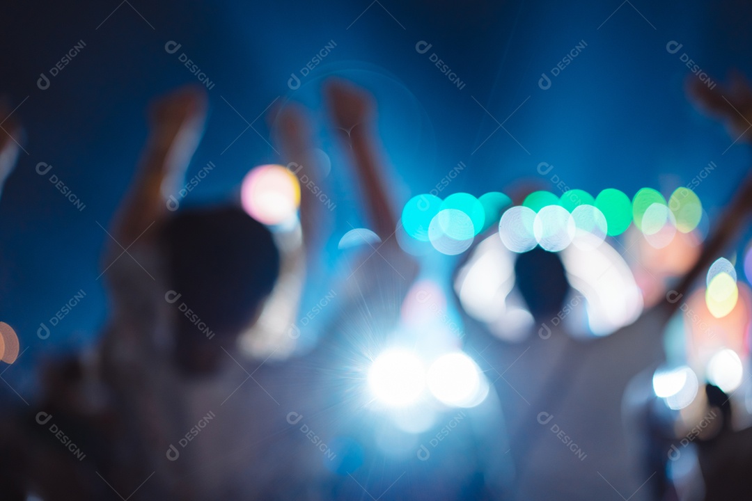 Multidão de mãos levantando as luzes do palco do concerto e a silhueta do público de fãs