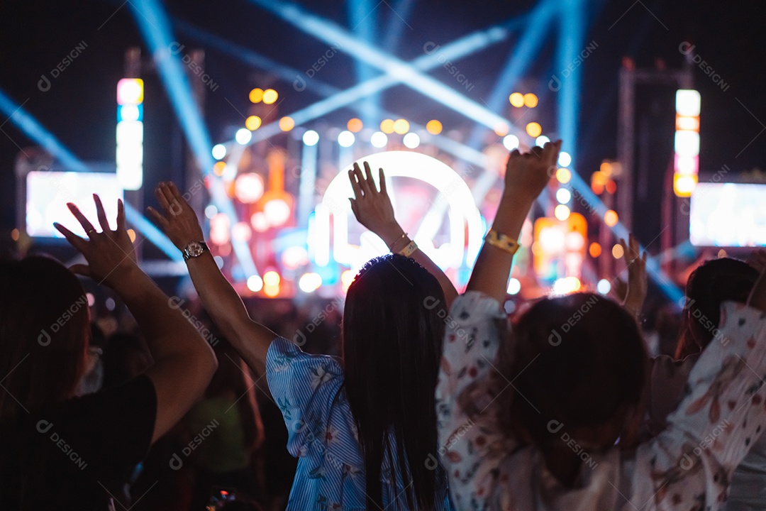 Multidão de mãos levantando as luzes do palco do concerto e a silhueta do público de fãs de pessoas
