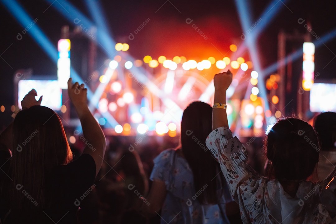 Multidão de mãos levantando as luzes do palco do concerto e a silhueta do público de fãs de pessoas