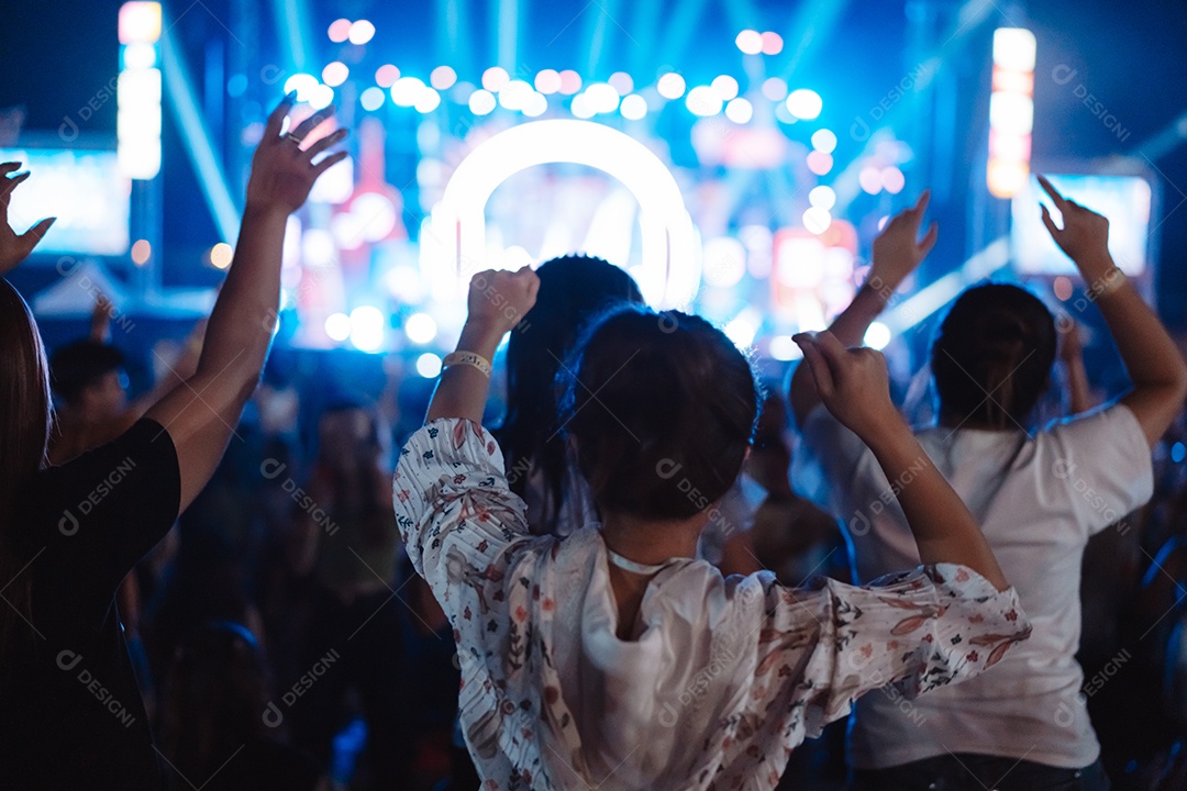 Multidão de mãos levantando as luzes do palco do concerto e a silhueta do público de fãs de pessoas