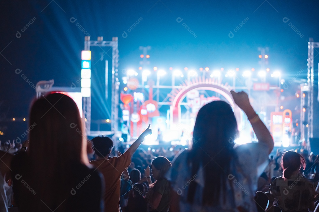 Multidão de mãos levantando as luzes do palco do concerto e a silhueta do público de fãs de pessoas