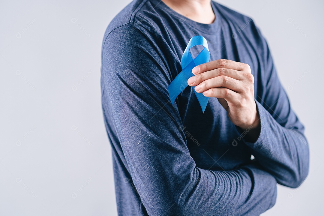 Mãos de homens segurando fita azul para apoiar as pessoas com câncer