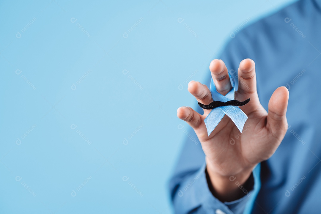 Homem mostrando fita azul com bigode para apoiar pessoas com câncer