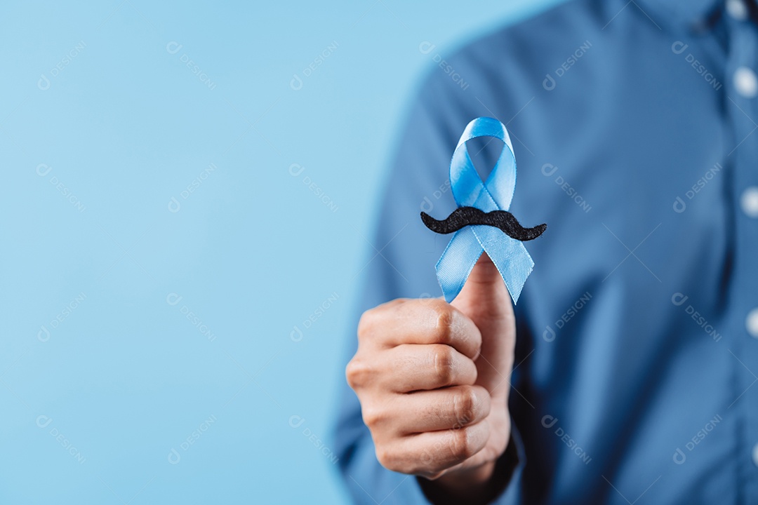 Homem mostrando fita azul com bigode para apoiar pessoas com câncer