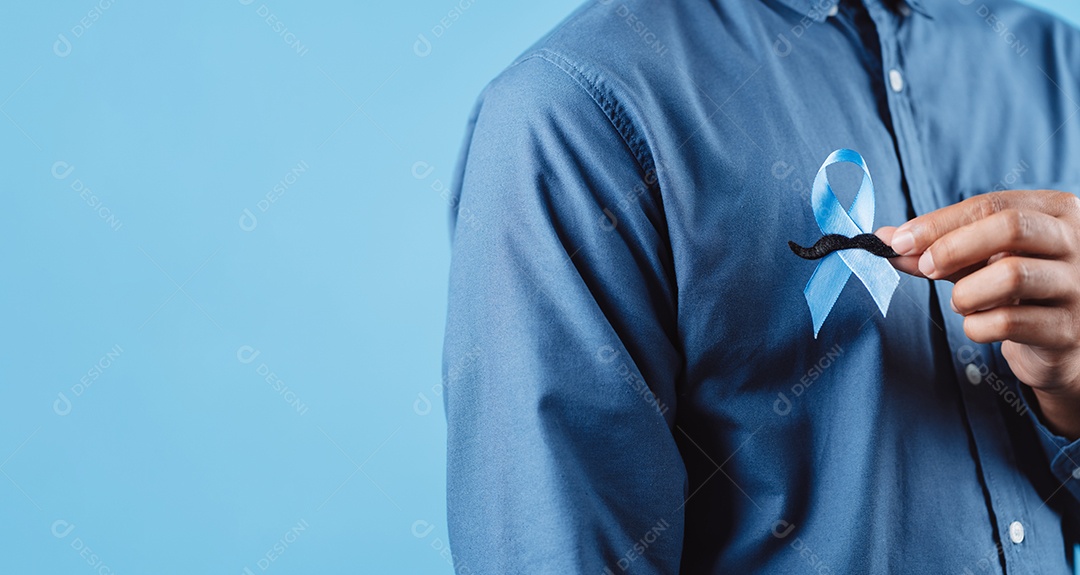 Homem mostrando fita azul com bigode para apoiar pessoas com câncer