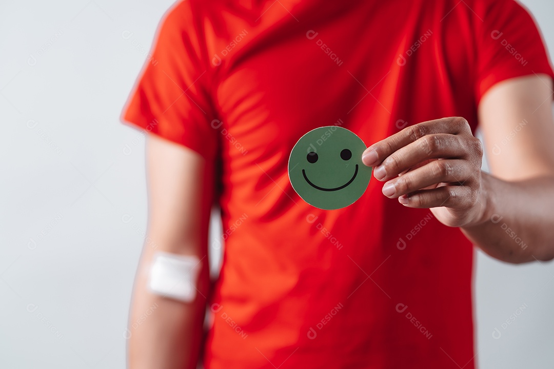 Homem segurando um rosto sorridente após doação de sangue, transfusão de sangue, dia mundial do doador de sangue