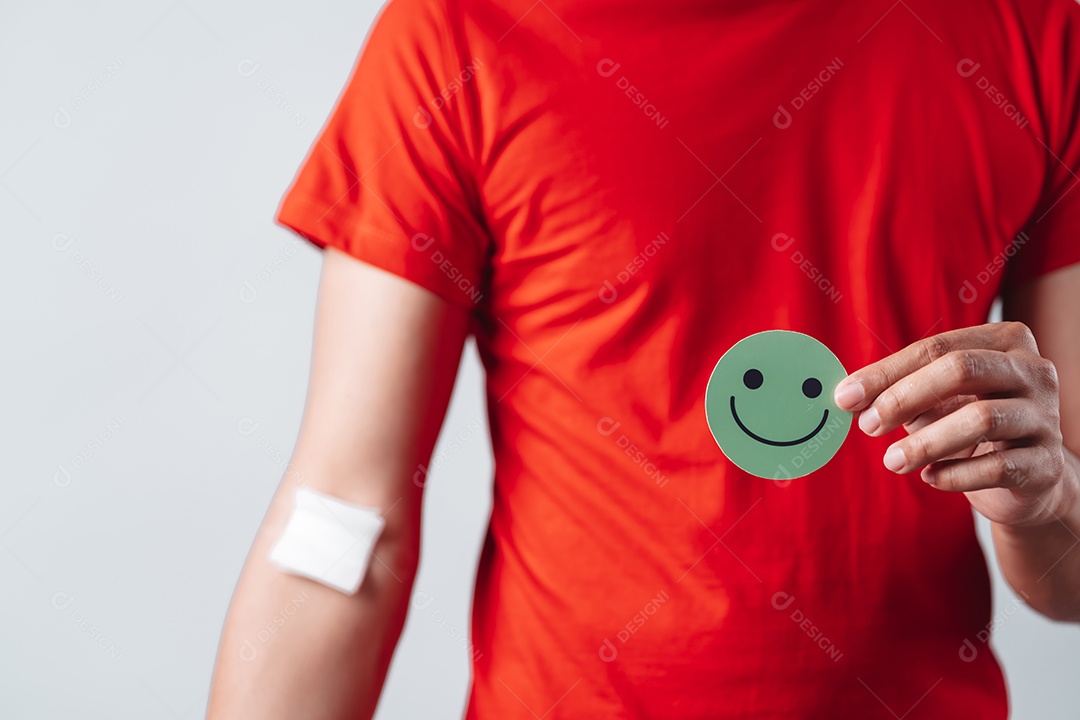 Homem segurando um rosto sorridente após doação de sangue, transfusão de sangue, dia mundial do doador de sangue