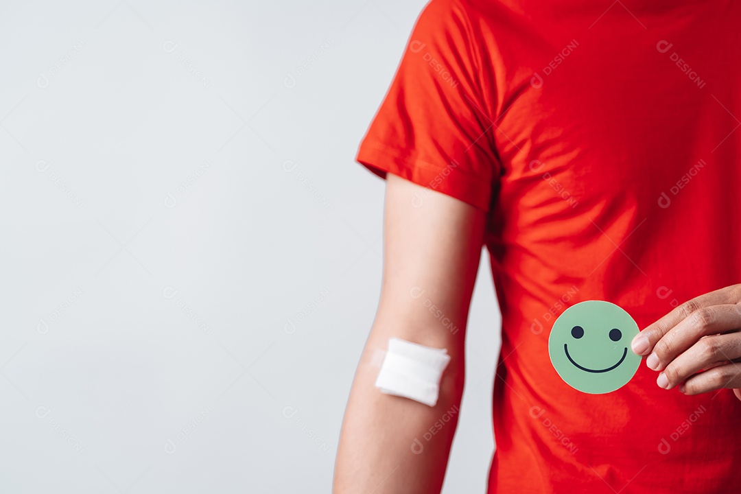 Homem segurando um rosto sorridente após doação de sangue, transfusão de sangue, dia mundial do doador de sangue