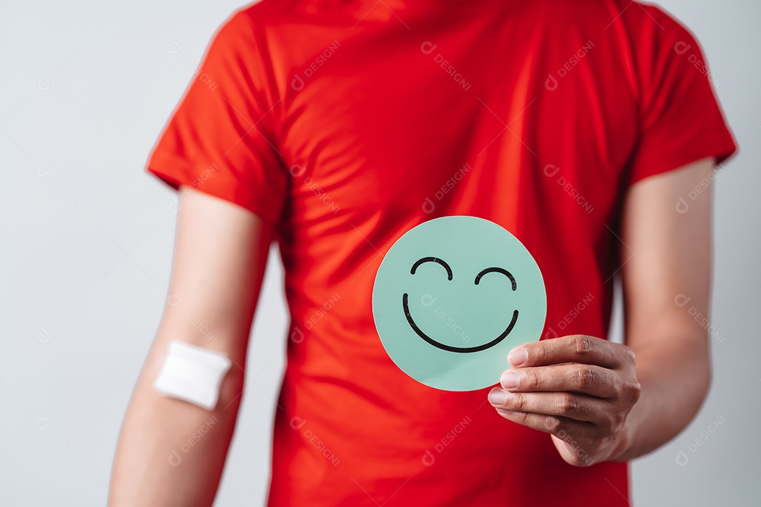 Homem segurando um rosto sorridente após doação de sangue, transfusão de sangue, dia mundial do doador de sangue