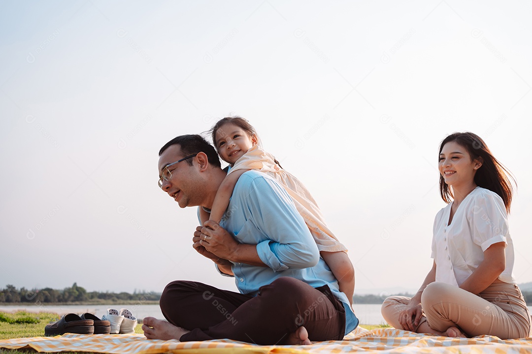 Família feliz no parque no fim de semana.