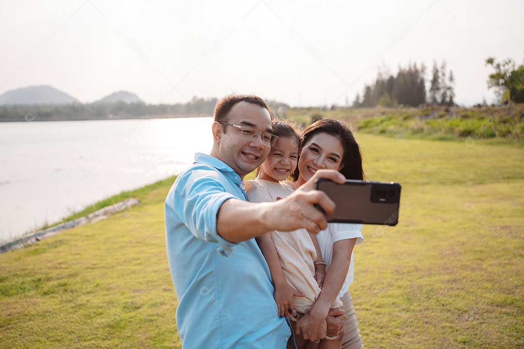 Família feliz na luz do sol do parque. família no fim de semana