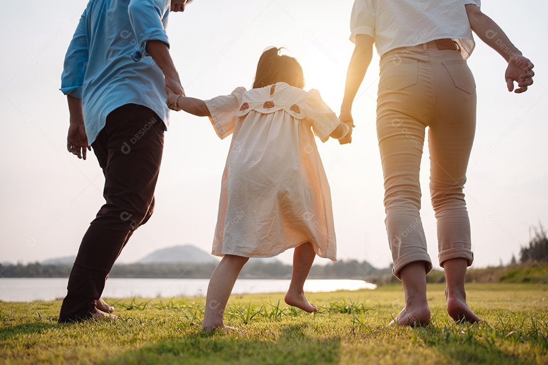 Família feliz na luz do sol do parque. família no fim de semana