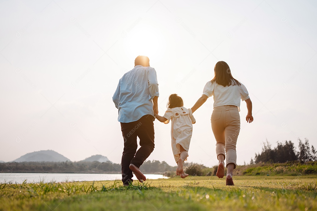 Família feliz na luz do sol do parque.