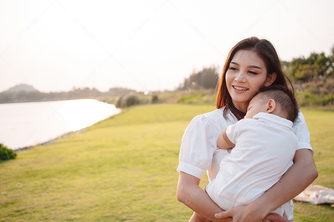 Mãe e filho juntos no pôr do sol do parque, família se divertindo juntos.