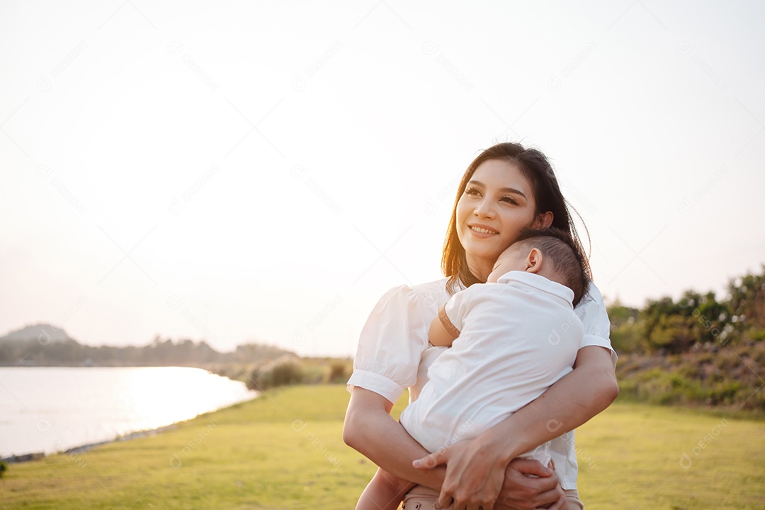 Mãe e filho juntos no pôr do sol do parque, família se divertindo juntos.