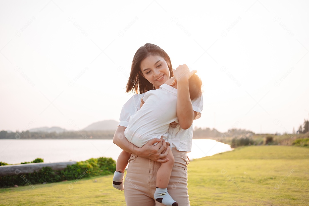 Mãe e filho juntos no pôr do sol do parque, família se divertindo juntos.