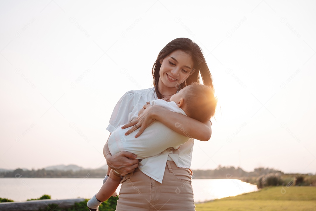 Mãe e filho juntos no pôr do sol do parque, família se divertindo juntos.